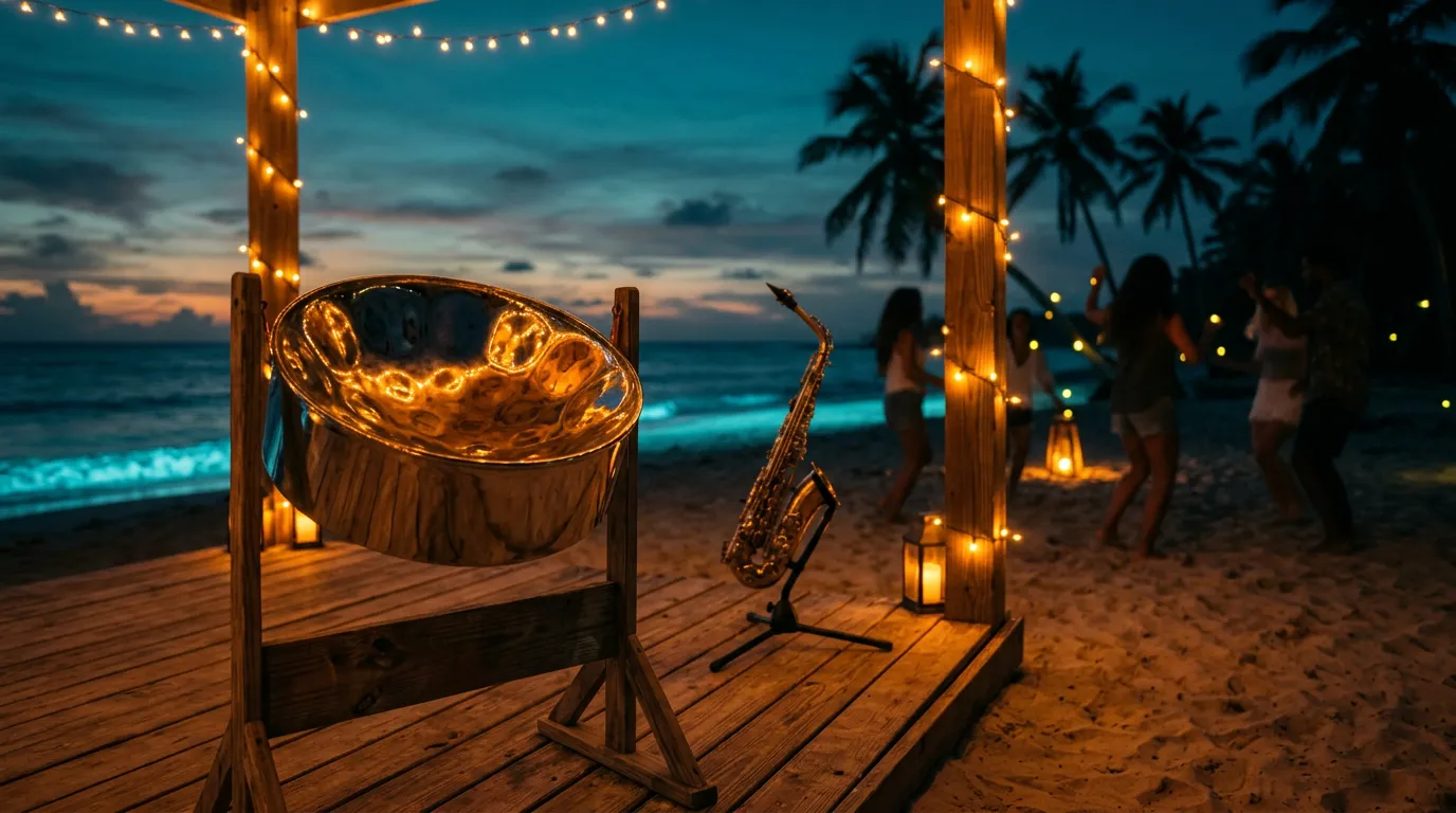 A steel pan drum and saxophone on a wooden beach stage at dusk, lit by amber string lights with palm silhouettes and a dark teal sea behind.